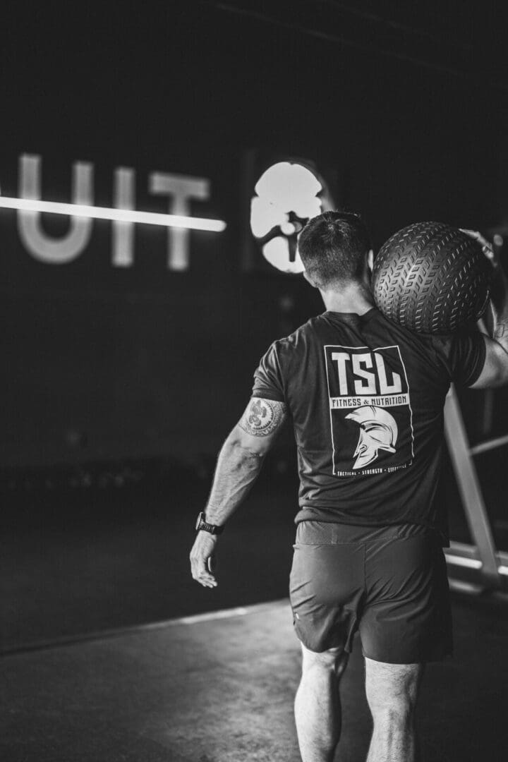 A man holding onto a ball while standing on the floor.